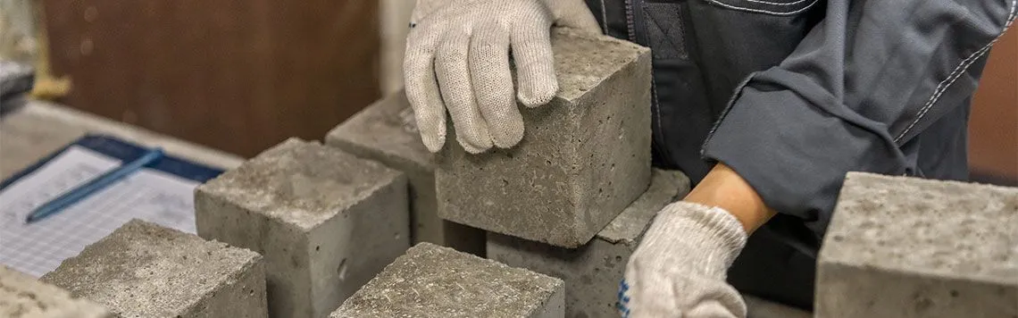 Concrete test cubes being handled ahead of compressive strength testing