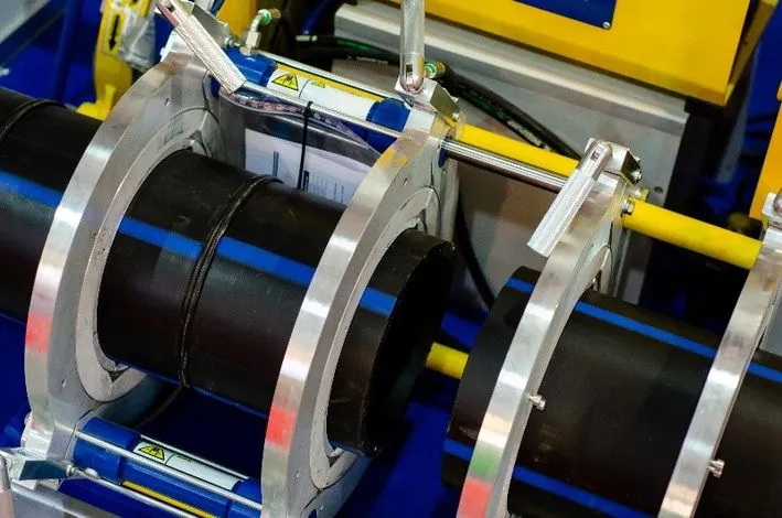 Butt fusion machine clamped onto polyethylene water main pipe